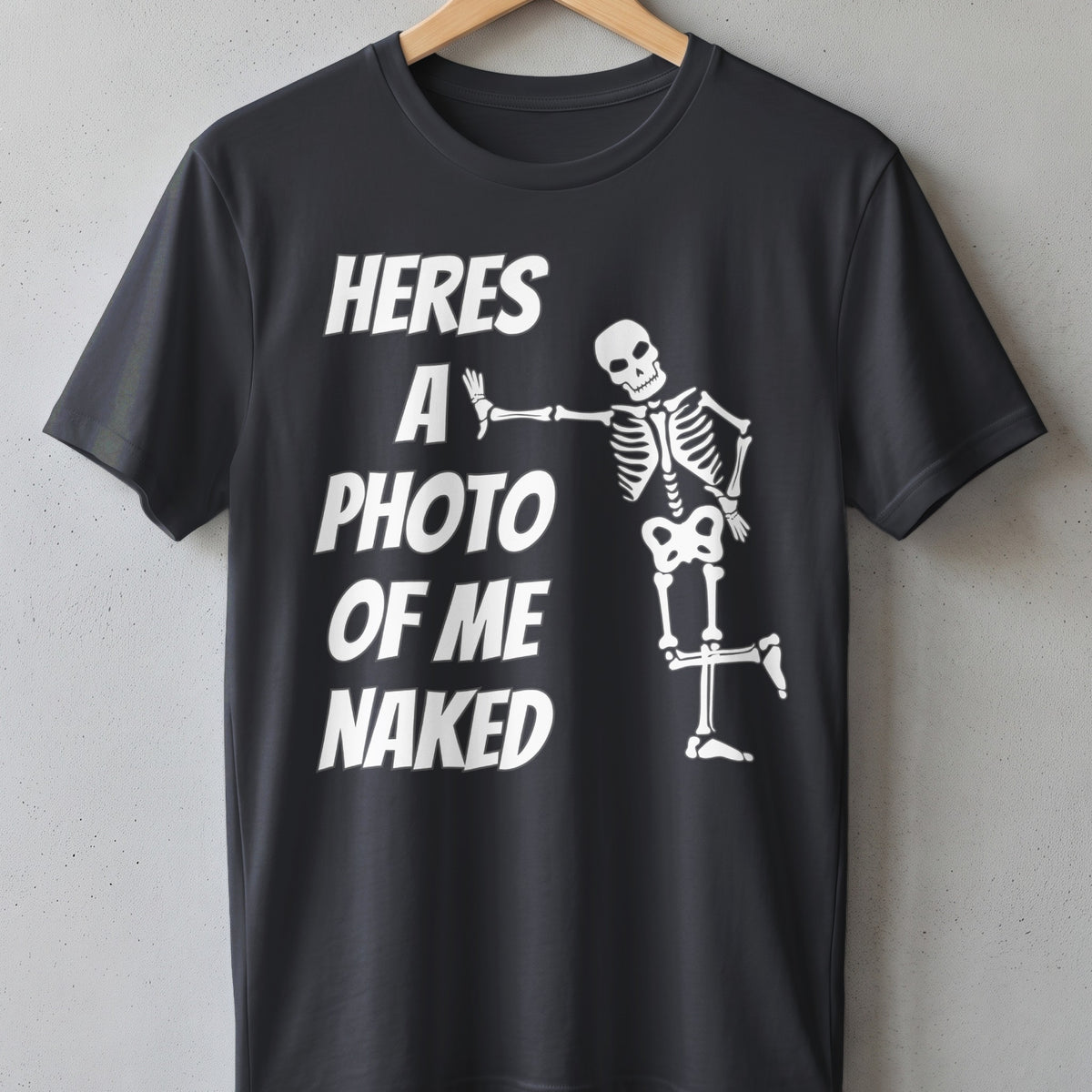Black t-shirt with white text "HERES A PHOTO OF ME NAKED" and a skeleton graphic.