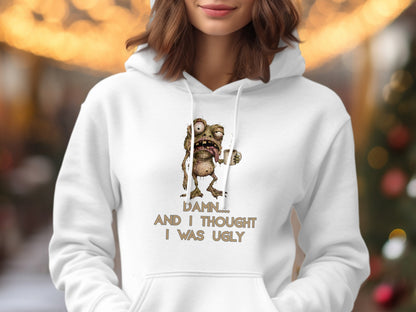 White hoodie with cartoon monster and text: "Damn.... And I thought I was ugly"