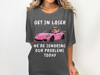 T-shirt with text "GET IN LOSER WE'RE IGNORING OUR PROBLEMS TODAY" and cat in car graphic.