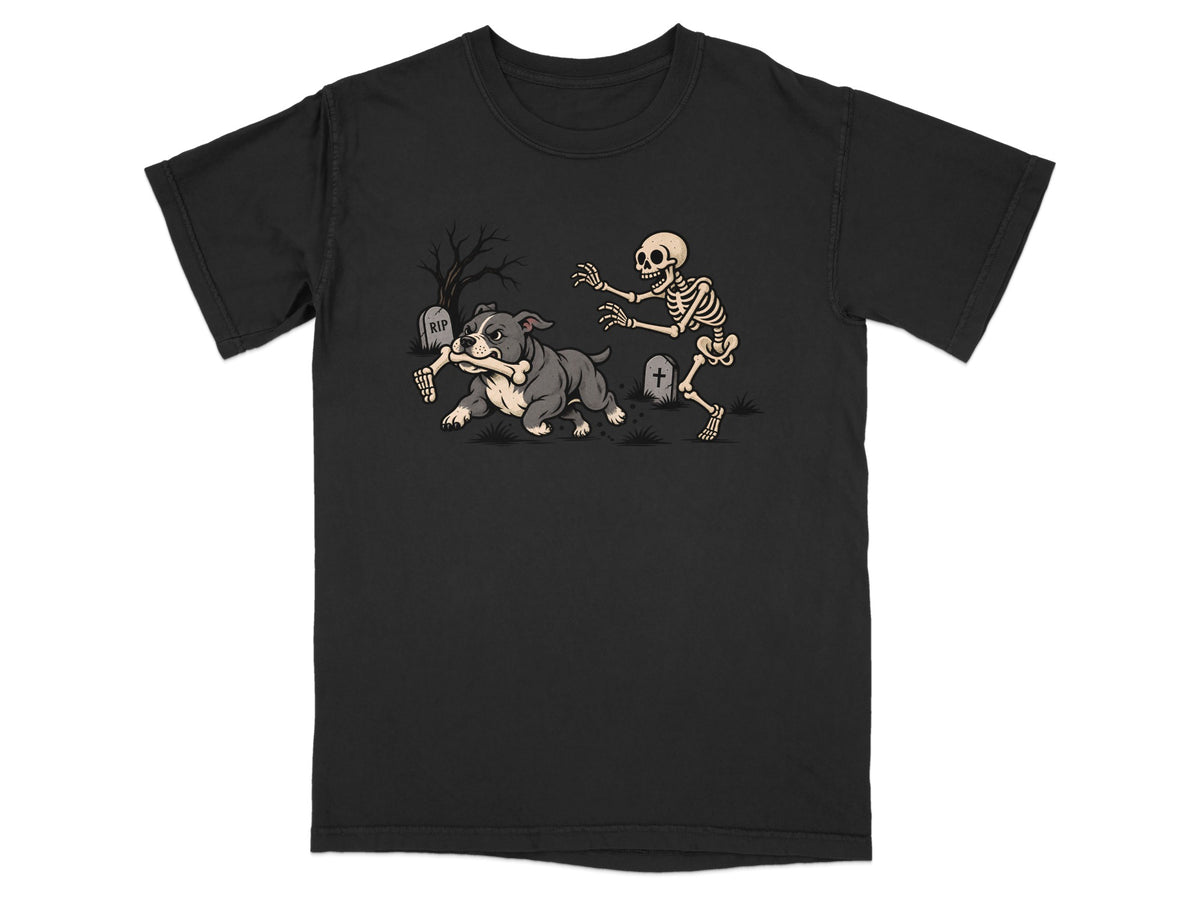 A black t-shirt features a graphic of a grey bulldog running away with a skeleton arm in a graveyard.
