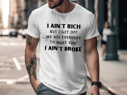 White t-shirt with black text reading I AIN'T RICH BUT I GET OFF MY ASS EVERYDAY TO MAKE SURE I AIN'T BROKE.