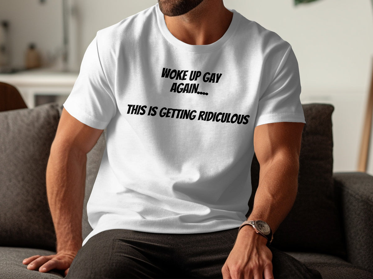 White t-shirt with black text reading "WOKE UP GAY AGAIN.... THIS IS GETTING RIDICULOUS".
