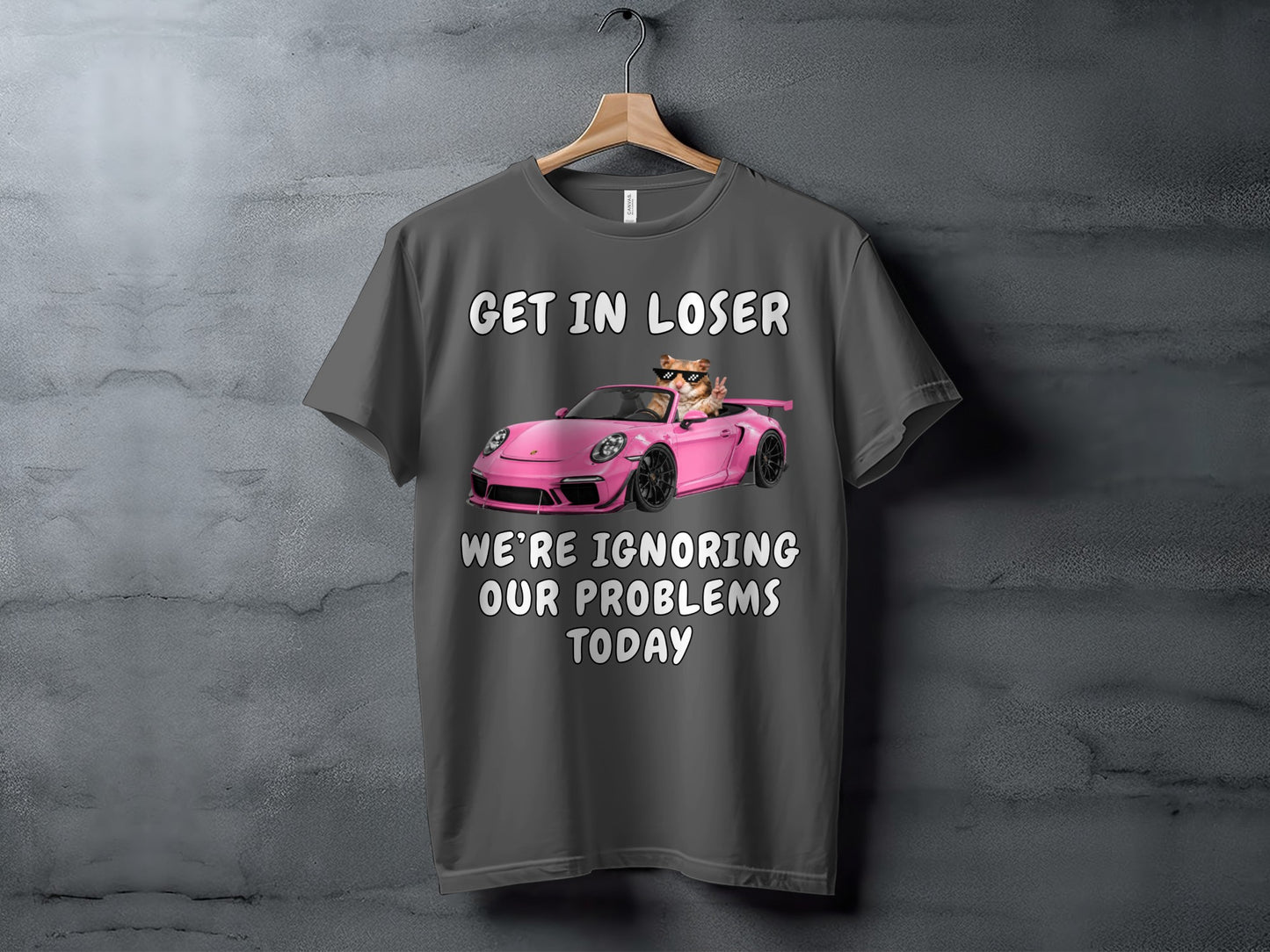 Gray t-shirt with text and a cat in a pink car.