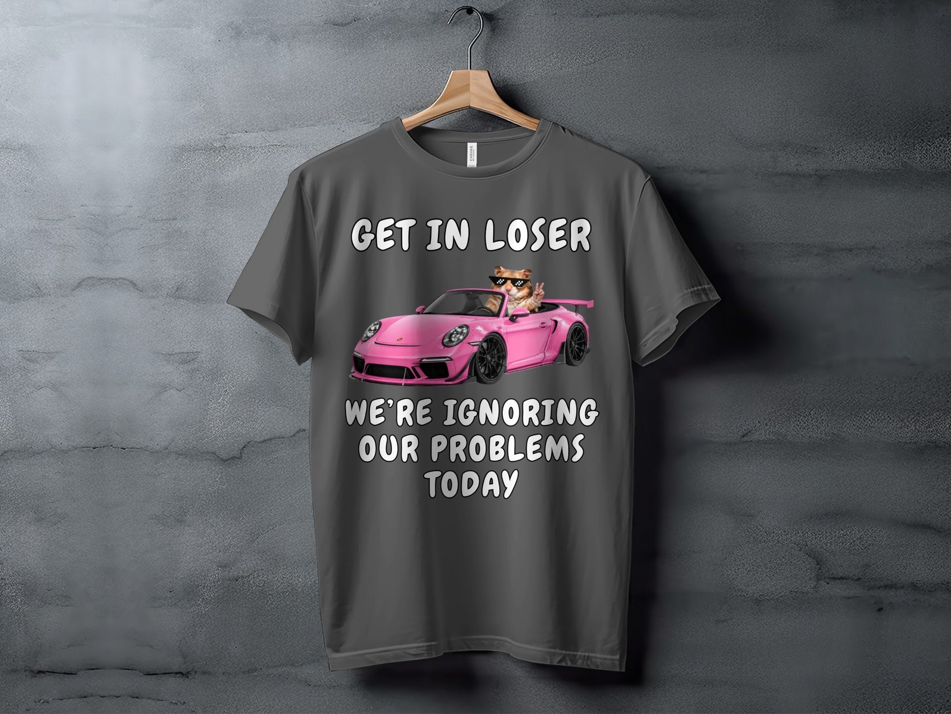 Gray t-shirt with text and a cat in a pink car.