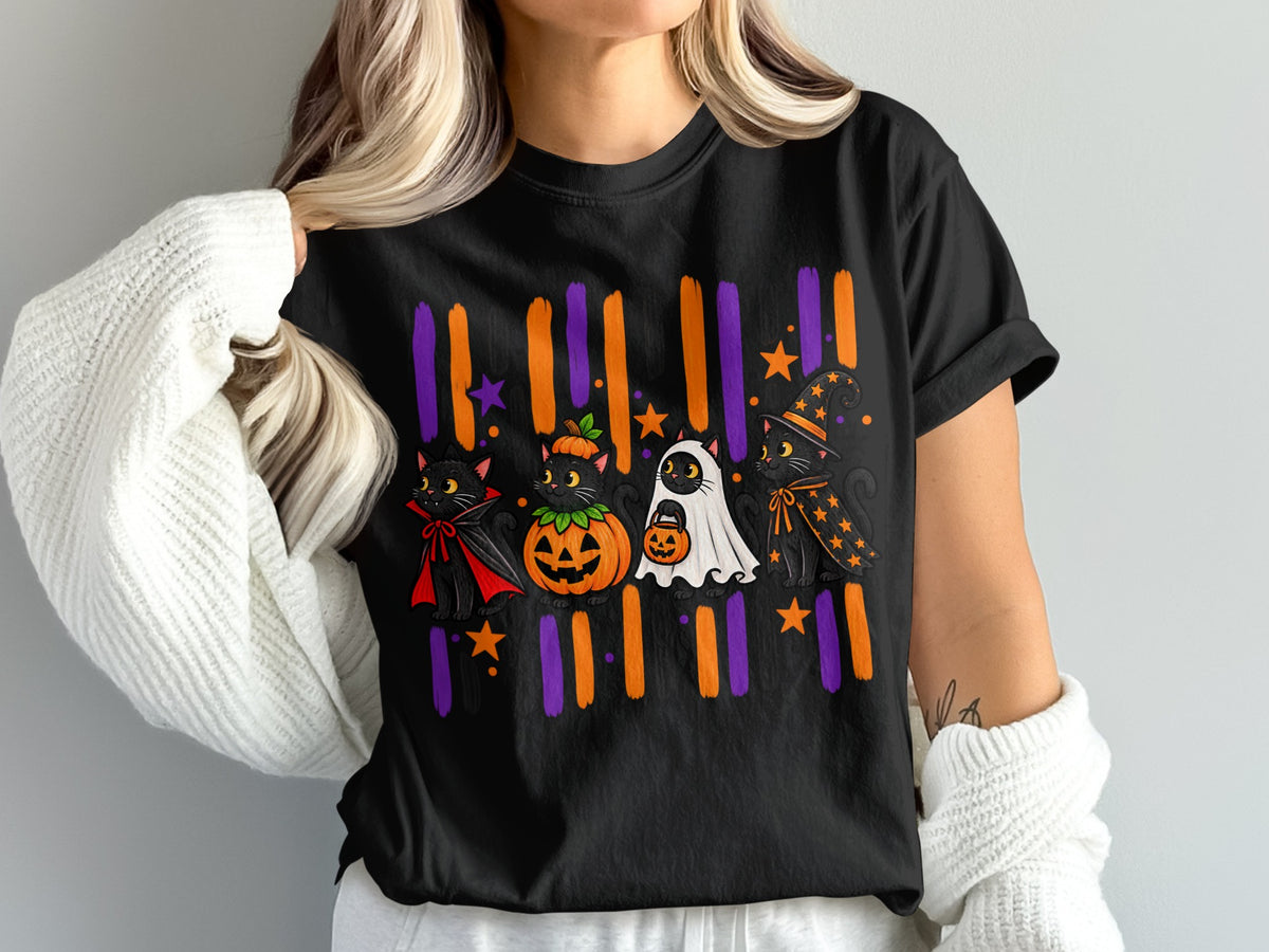 Black t-shirt with Halloween graphic of cats dressed as a vampire, pumpkin, ghost, and witch.