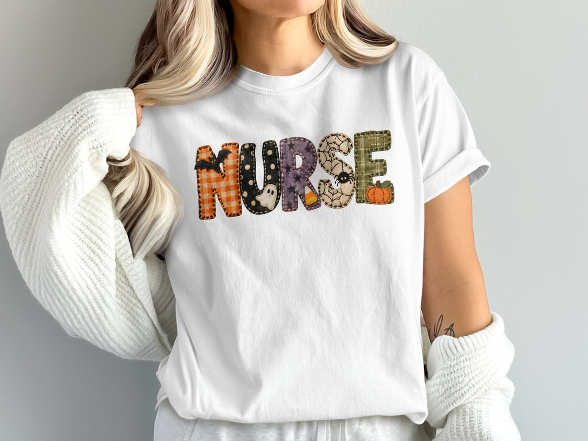 A woman wearing a white t-shirt featuring the word NURSE in Halloween-themed patterned letters.