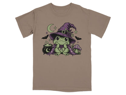 Brown short-sleeve t-shirt featuring a graphic of a green frog wearing a witch hat and cape.