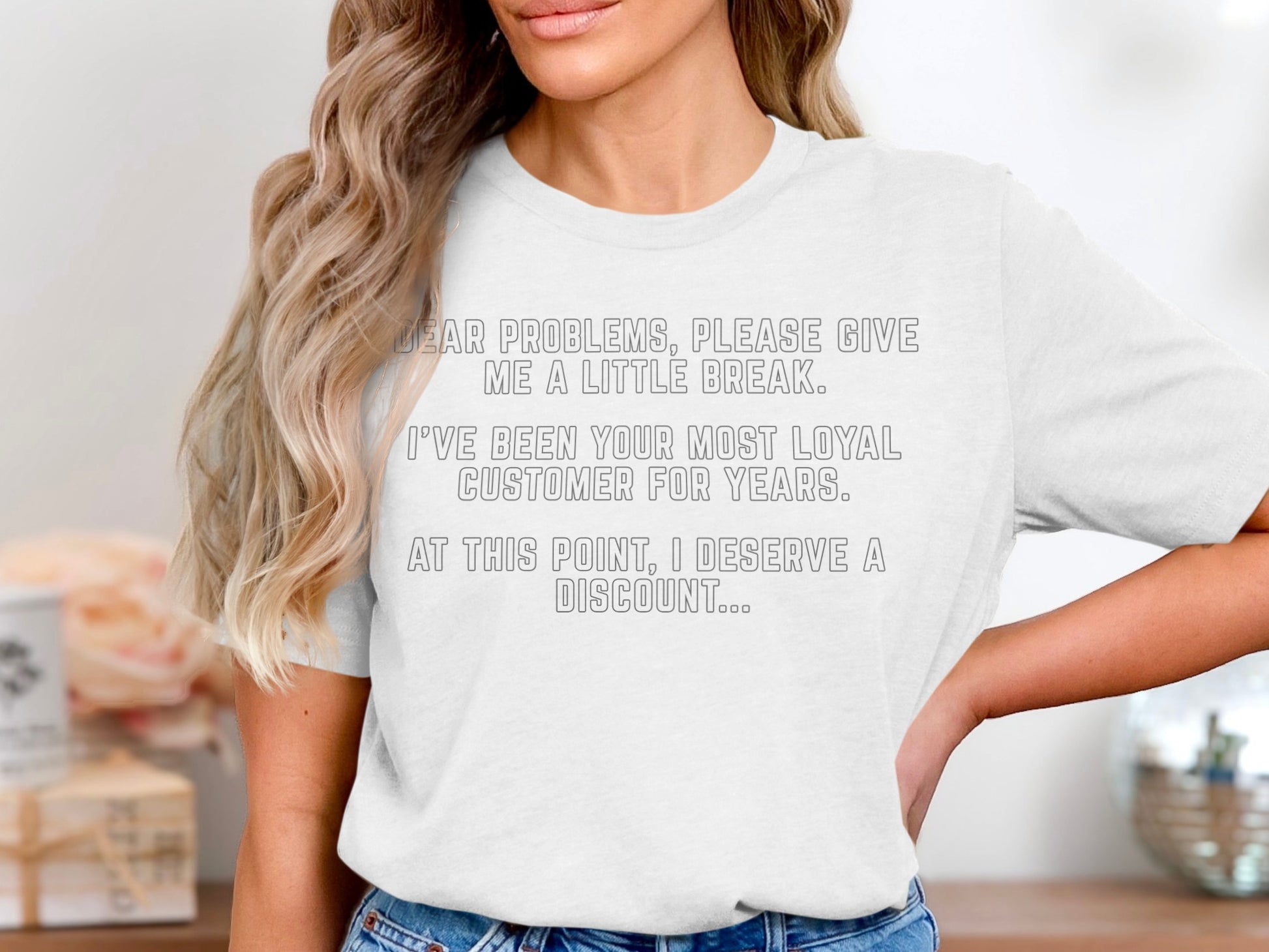 White t-shirt with text: "Dear problems, please give me a little break. I've been your most loyal customer for years. At this point, I deserve a discount..."