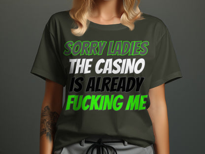 Dark green t-shirt with text: SORRY LADIES THE CASINO IS ALREADY FUCKING ME.