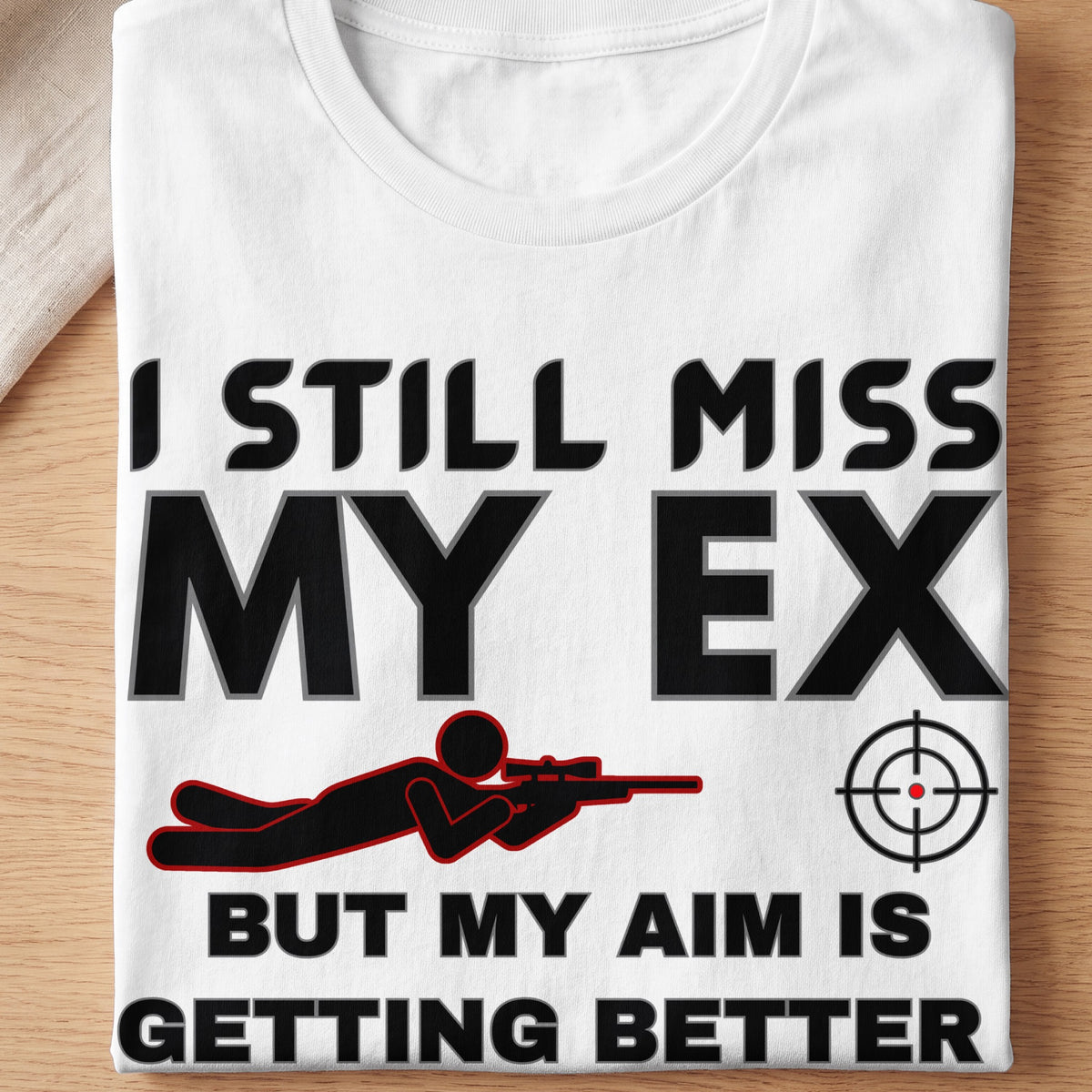 White t-shirt with text "I STILL MISS MY EX BUT MY AIM IS GETTING BETTER" and graphics.