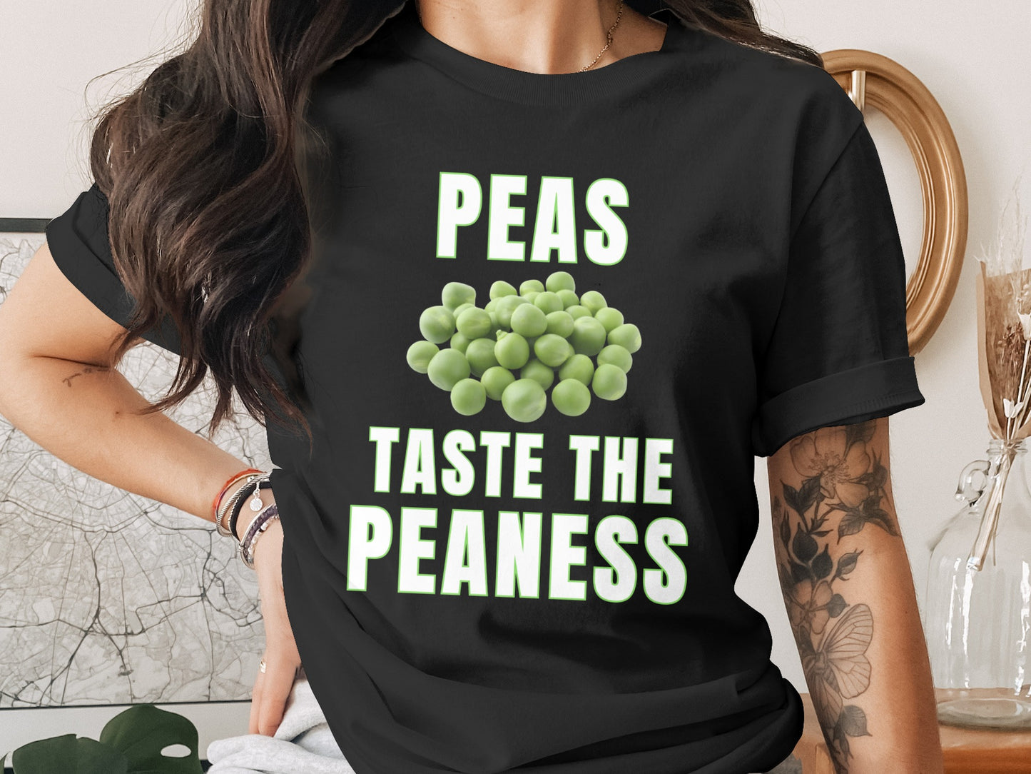 Black t-shirt with white text "PEAS TASTE THE PEANESS" and pile of peas.