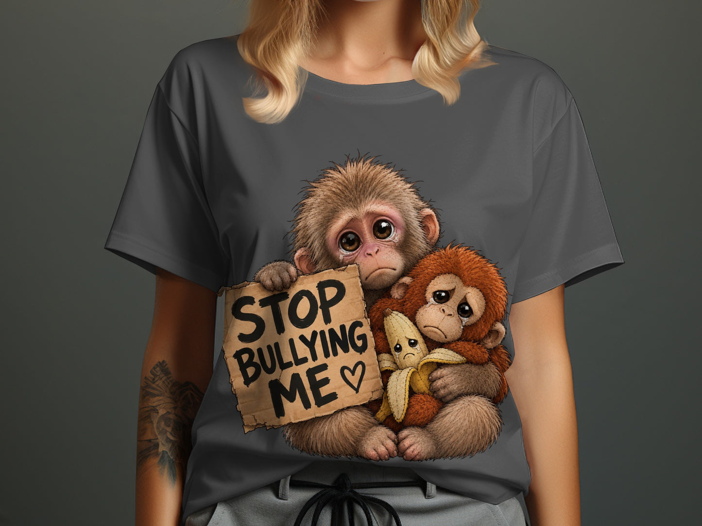 Two sad monkeys, one holding a sign that says "STOP BULLYING ME" and a banana.