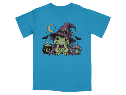 A bright blue t-shirt printed with a cute green frog wearing a witch hat and cape.