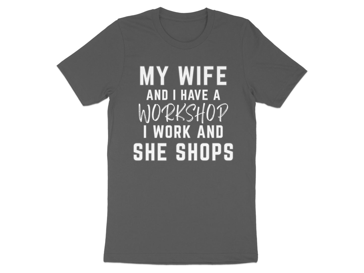 Dark gray t-shirt with white text: My wife and I have a workshop, I work and she shops.