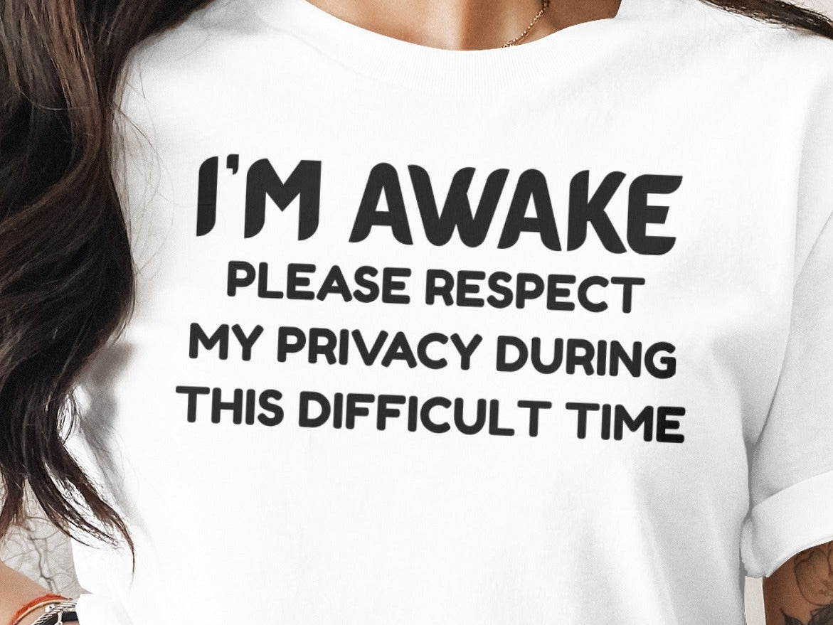 White t-shirt with black text: "I'M AWAKE" and "PLEASE RESPECT MY PRIVACY DURING THIS DIFFICULT TIME".