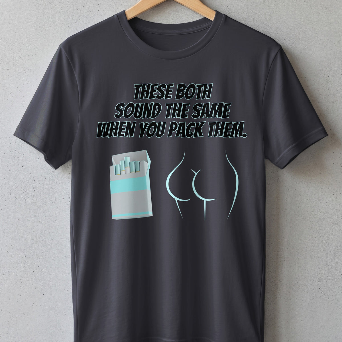 Dark grey t-shirt with "THESE BOTH SOUND THE SAME WHEN YOU PACK THEM" and cartoon.