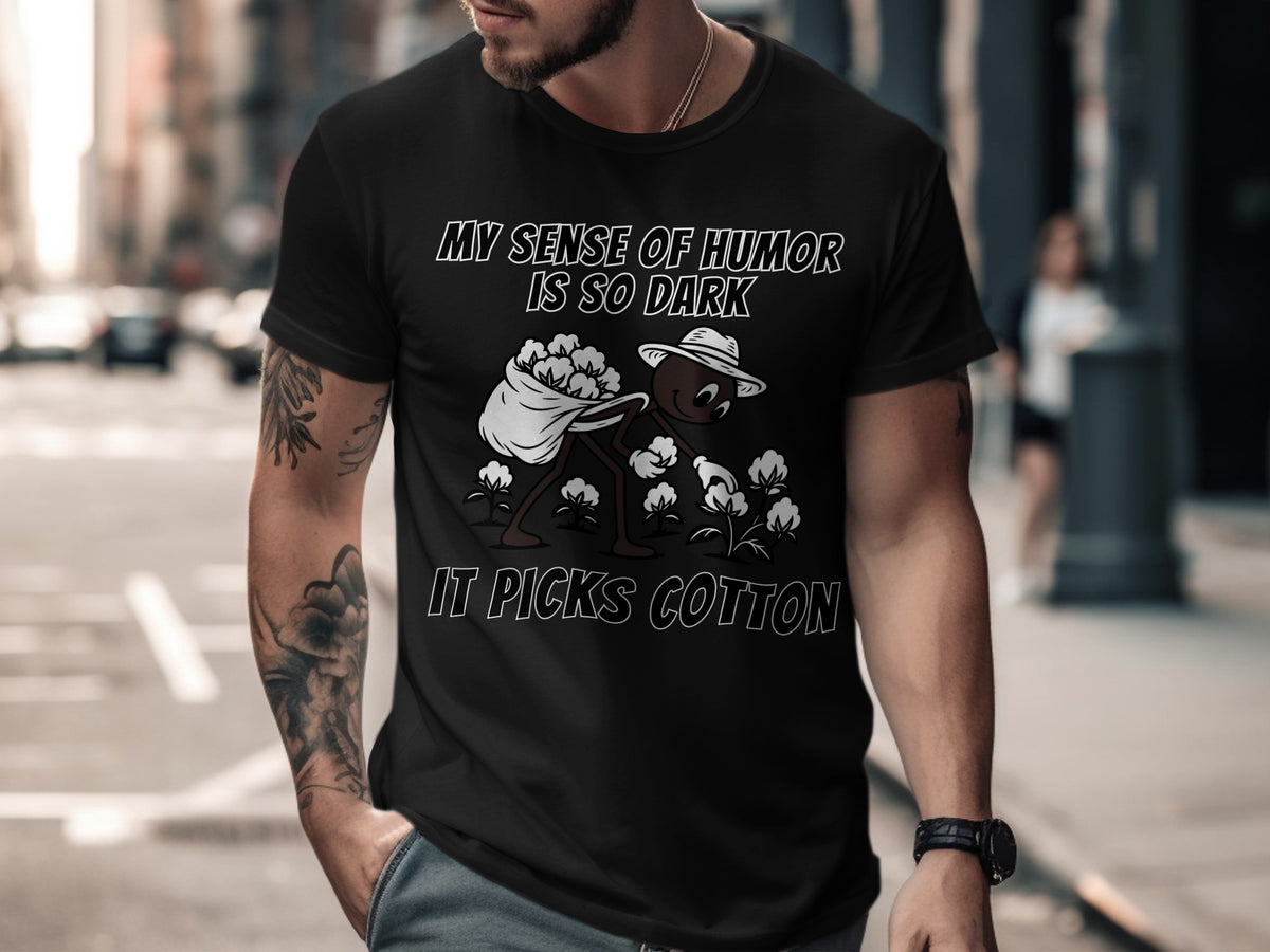 Black t-shirt with text "MY SENSE OF HUMOR IS SO DARK IT PICKS COTTON" and graphic.