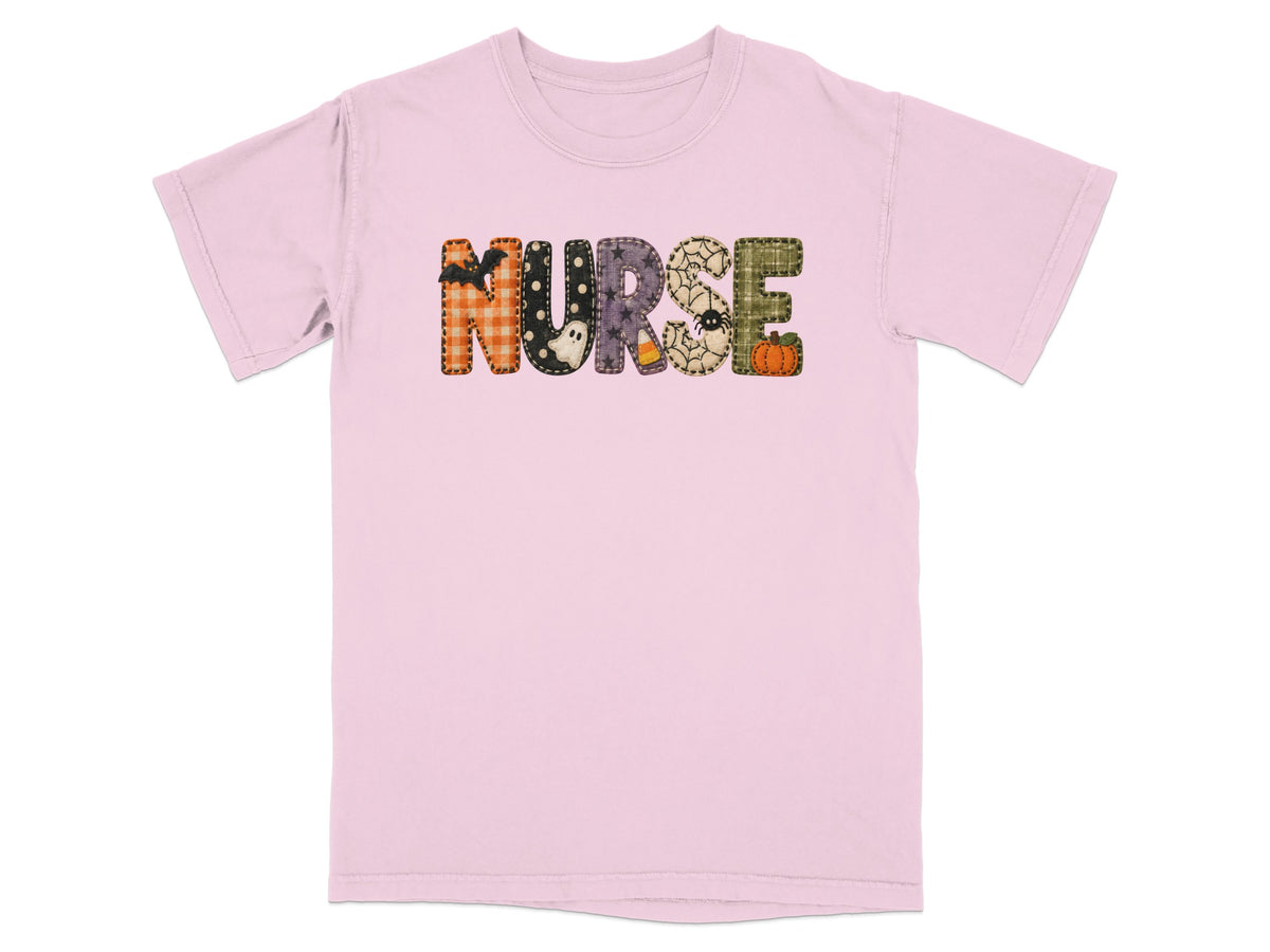 Light pink t-shirt with the word NURSE spelled out in patterned Halloween-themed patchwork letters.