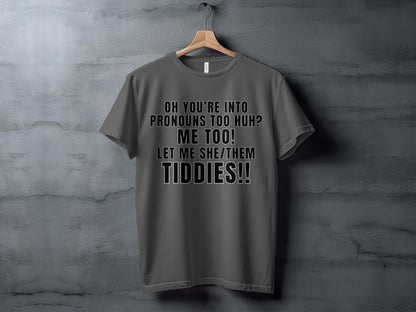 Grey t-shirt with text "Oh you're into pronouns too huh? Me too! Let me she/them tiddies!!"
