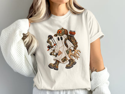 A woman wearing a cream t-shirt with a graphic of a ghost dressed as a hunter holding a bow and antlers.