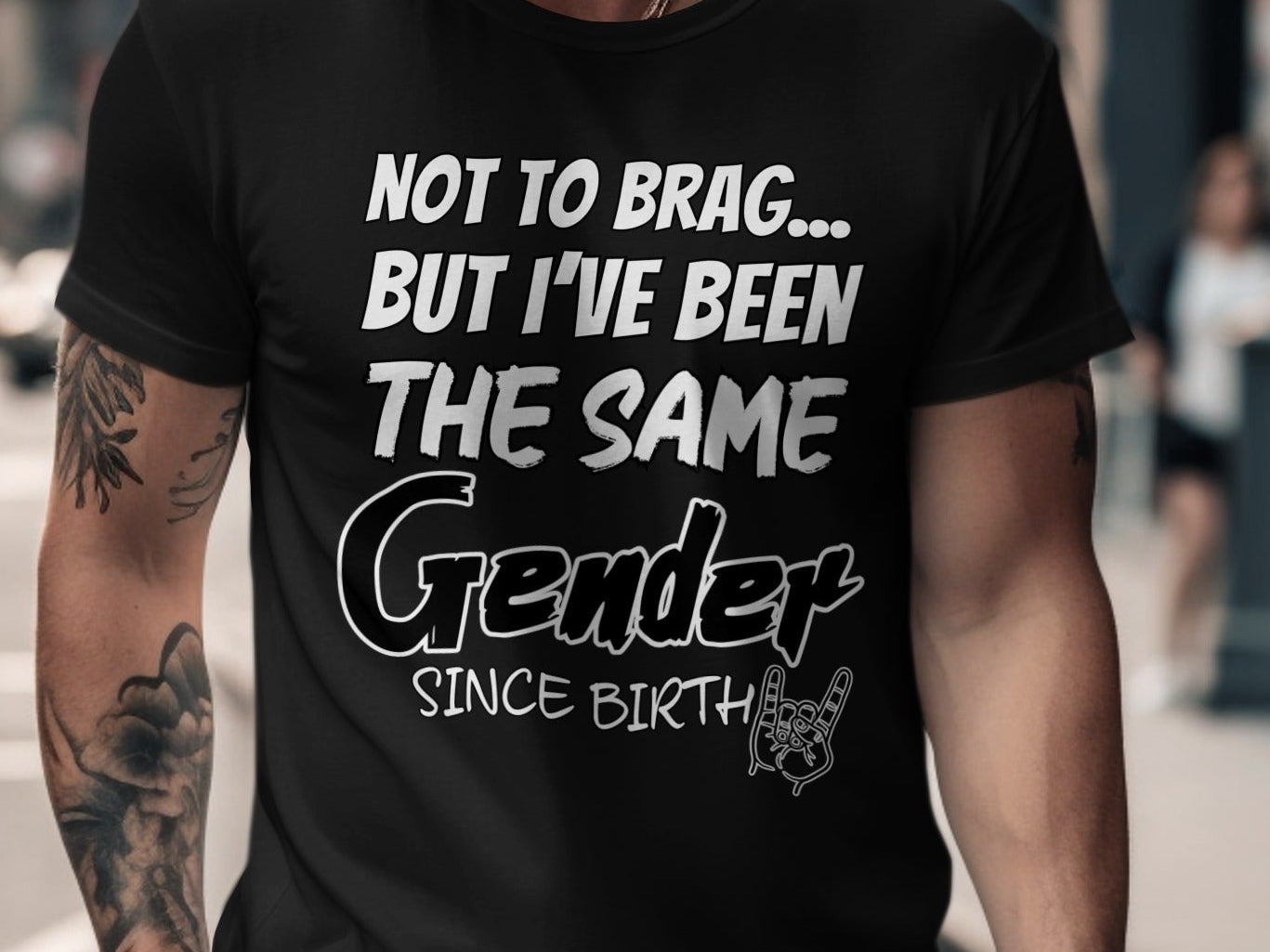 Black t-shirt with "Not to brag... but I've been the same Gender since birth" text and rock on hand graphic.