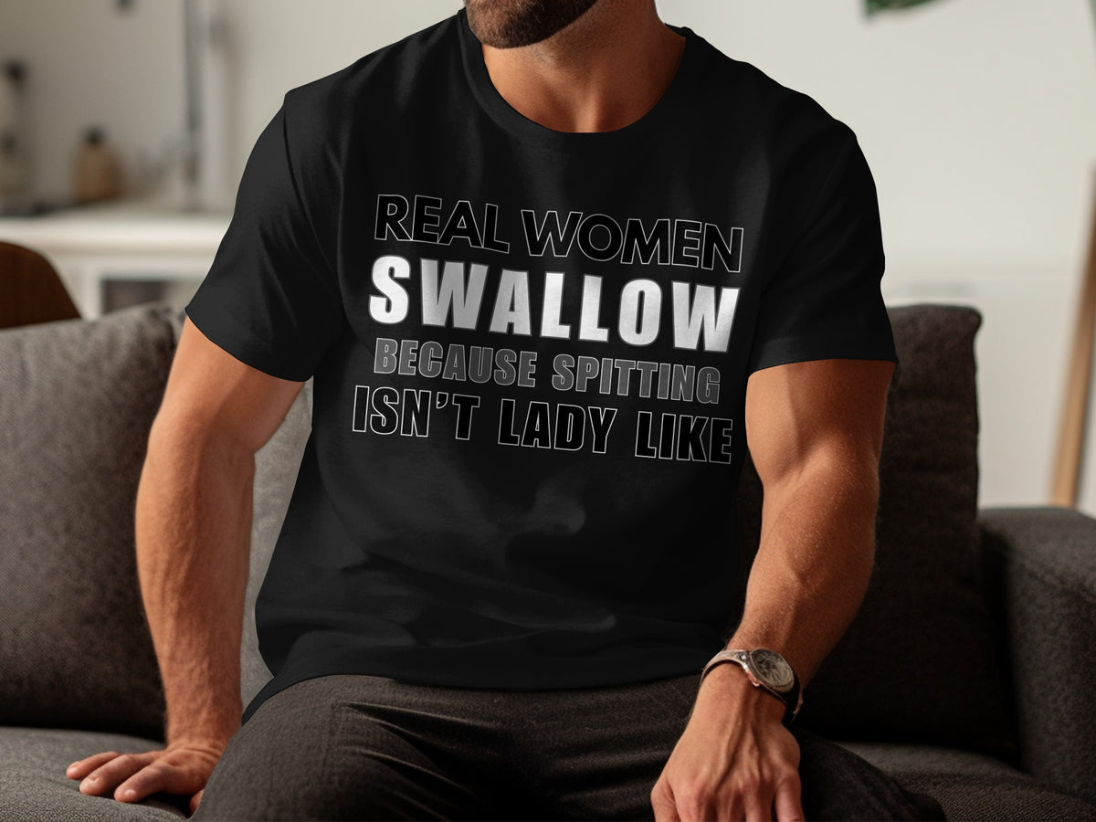 Black t-shirt with white text that reads "REAL WOMEN SWALLOW BECAUSE SPITTING ISN'T LADY LIKE."