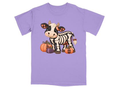 Skeleton cow with plaid accents and pumpkins on a light purple t-shirt.
