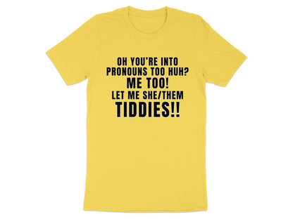 Yellow t-shirt with black text reading "OH YOU'RE INTO PRONOUNS TOO HUH? ME TOO! LET ME SHE/THEM TIDDIES!!"