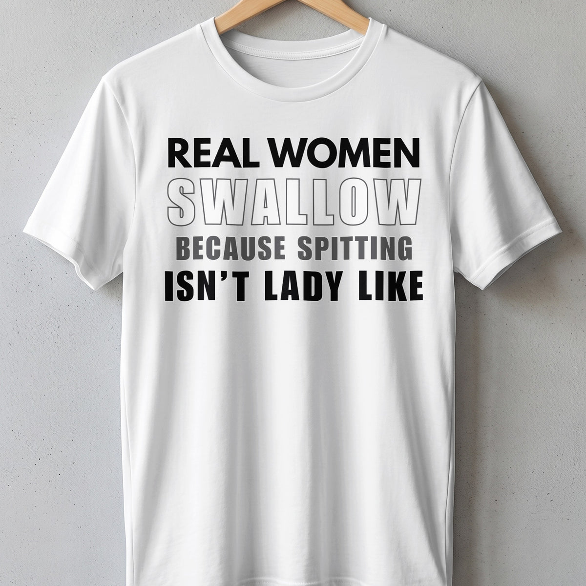 White t-shirt with black text: "REAL WOMEN SWALLOW BECAUSE SPITTING ISN'T LADY LIKE"