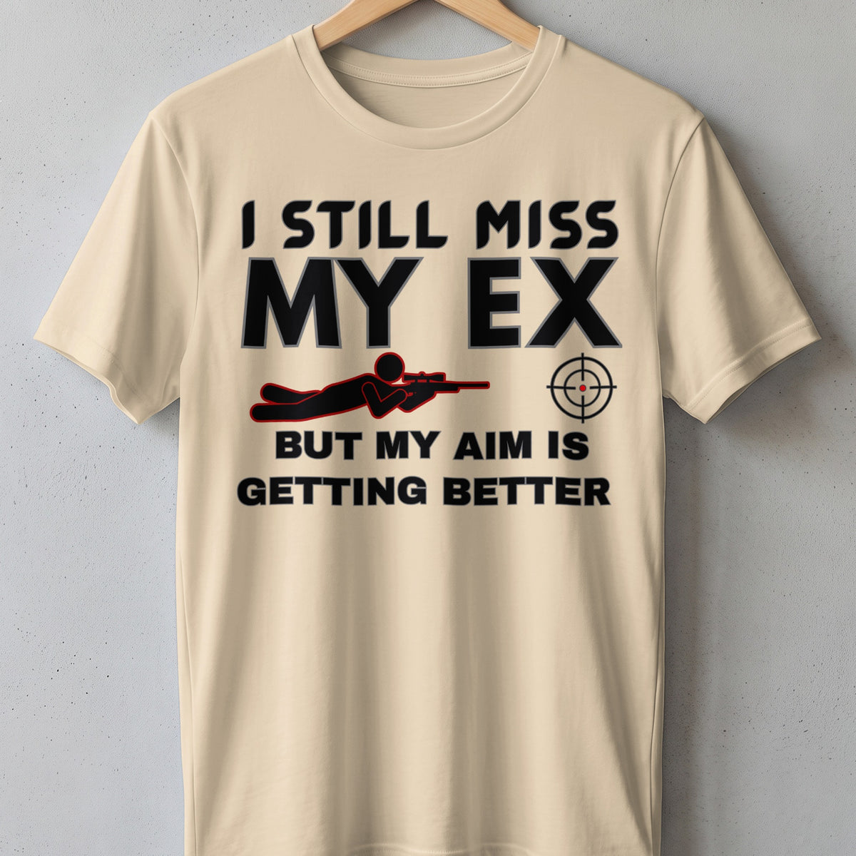 Cream t-shirt with text "I STILL MISS MY EX BUT MY AIM IS GETTING BETTER."