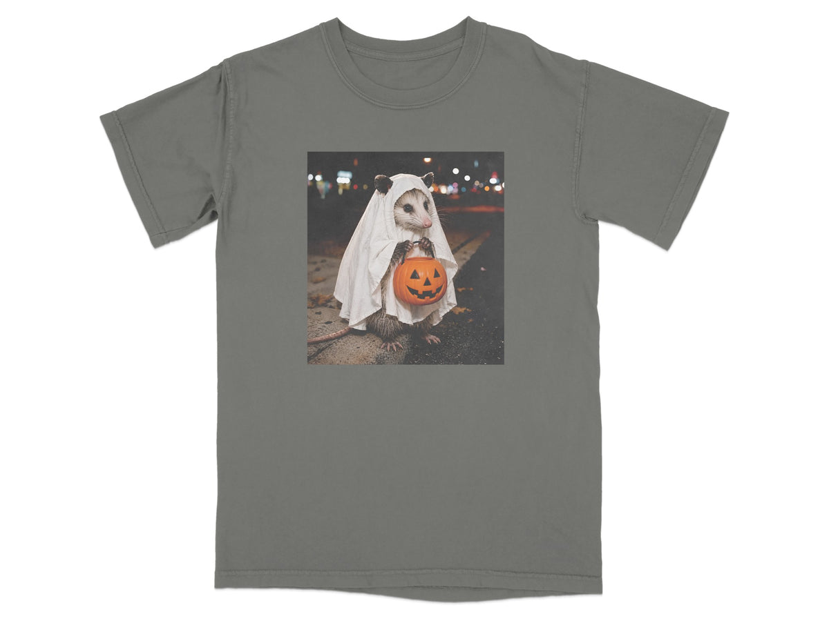 Opossum in ghost costume holding a jack-o'-lantern candy bucket.