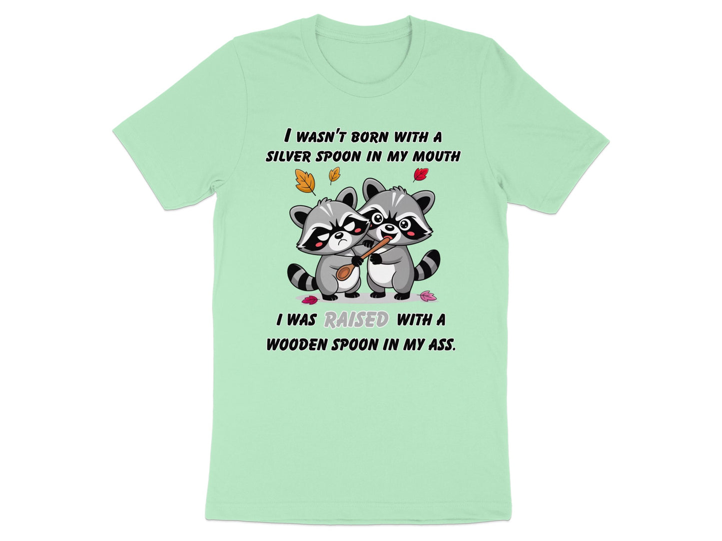 Two raccoons share a wooden spoon; text reads "I WASN'T BORN WITH A SILVER SPOON IN MY MOUTH".