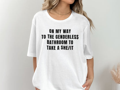 White t-shirt with black text: "ON MY WAY TO THE GENDERLESS BATHROOM TO TAKE A SHE/IT".