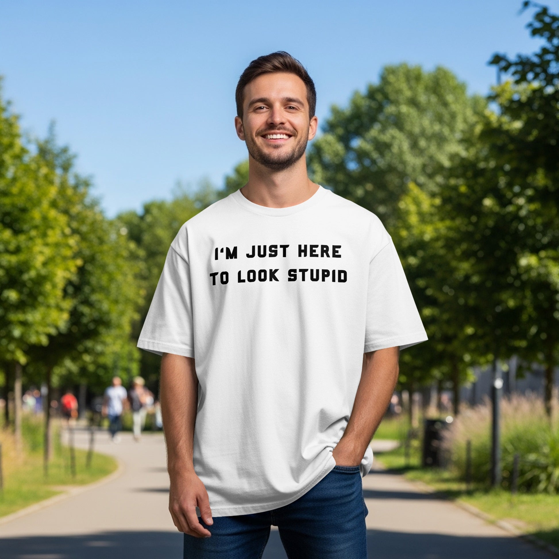 Man wearing a white t-shirt with black text "I'M JUST HERE TO LOOK STUPID".