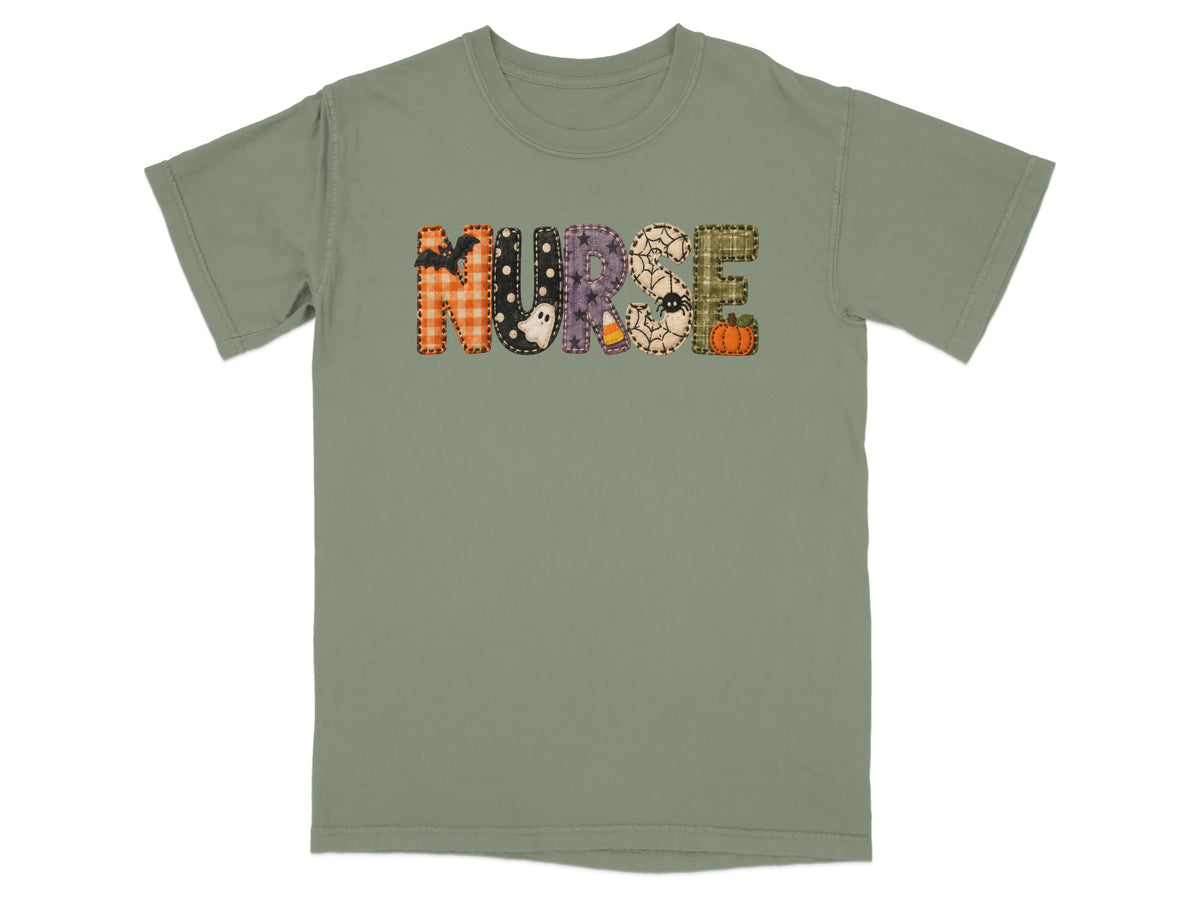 An olive green short-sleeved t-shirt features the word NURSE in patterned Halloween-themed block letters.