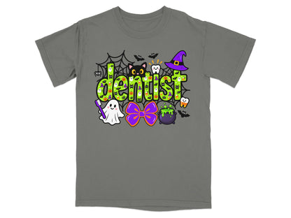 A gray t-shirt with a green Halloween-themed design featuring the word dentist surrounded by festive icons.