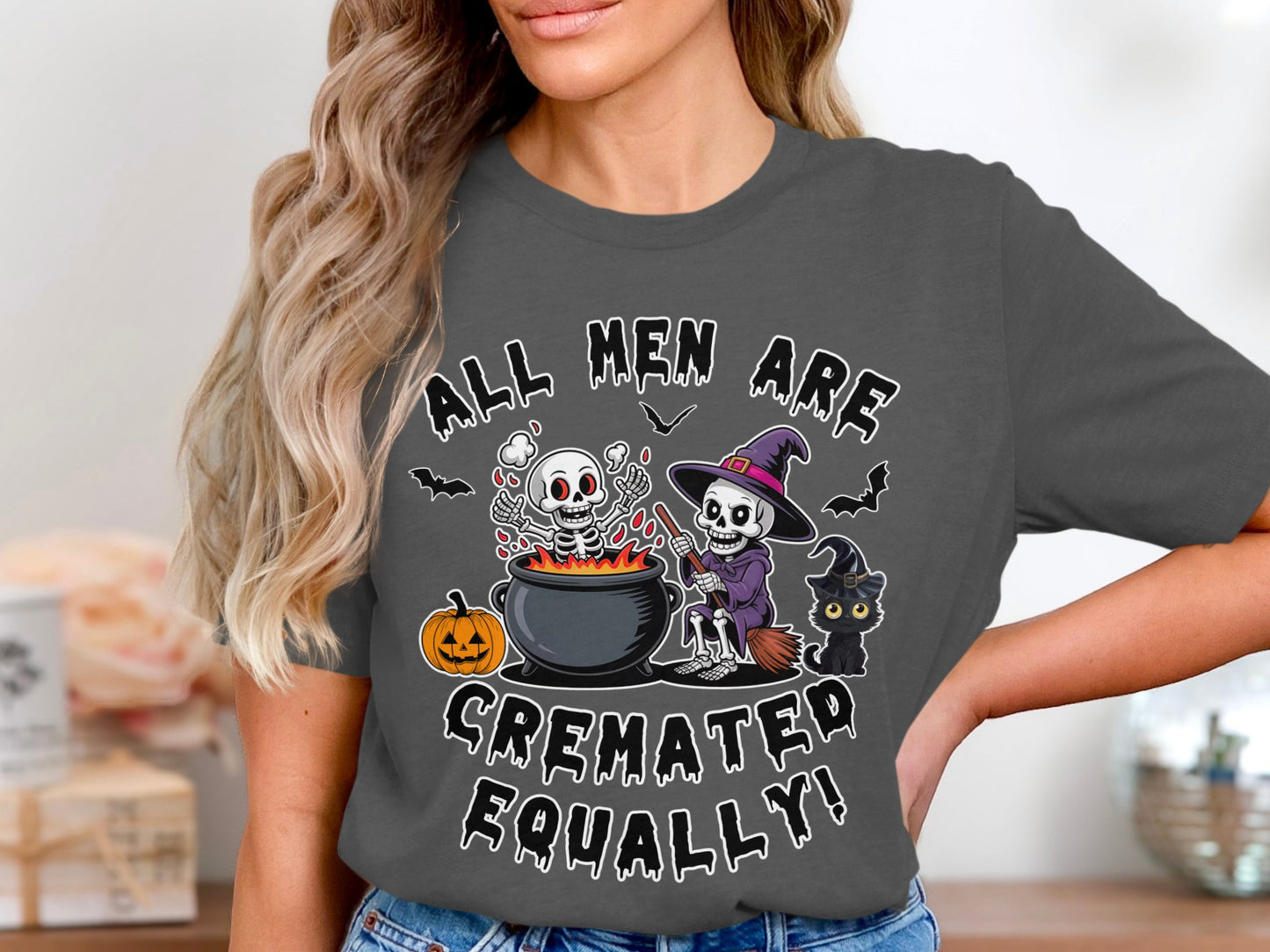 "All men are cremated equally!" text with skeletons, witch, black cat, and pumpkin graphic.