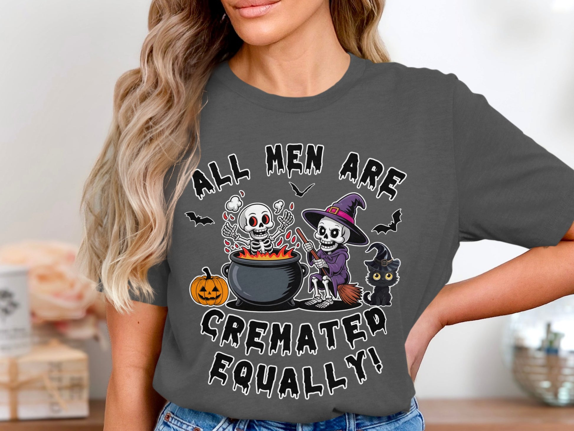 "All men are cremated equally!" text with skeletons, witch, black cat, and pumpkin graphic.