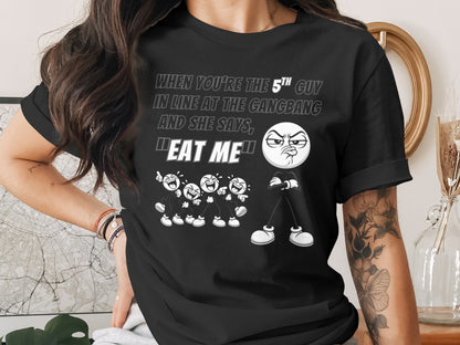 Black t-shirt with text and cartoon characters: "When you're the 5th guy in line at the gangbang and she says, 'Eat me'."