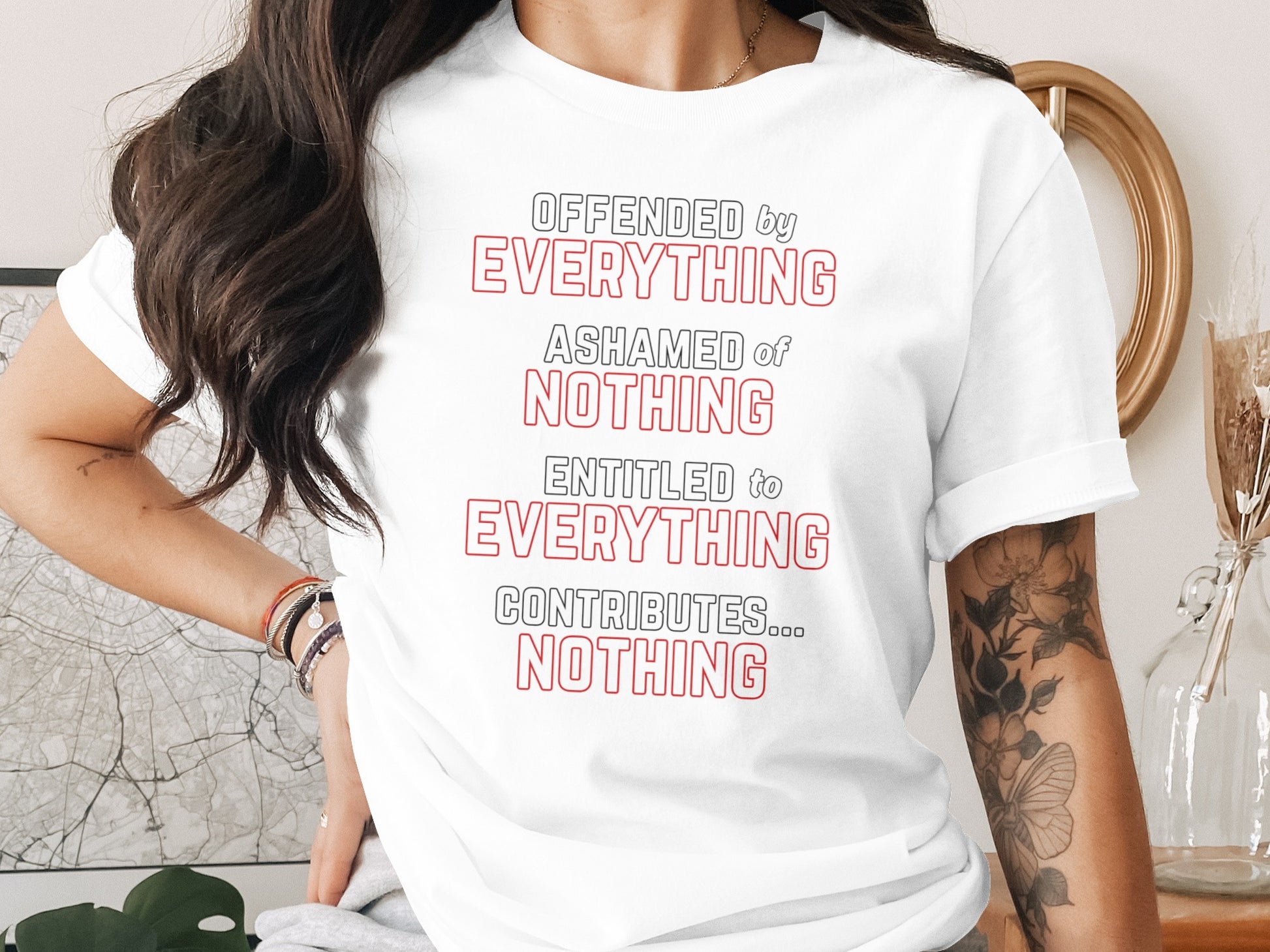 White t-shirt with red and black text: "OFFENDED by EVERYTHING ASHAMED of NOTHING ENTITLED to EVERYTHING CONTRIBUTES... NOTHING".