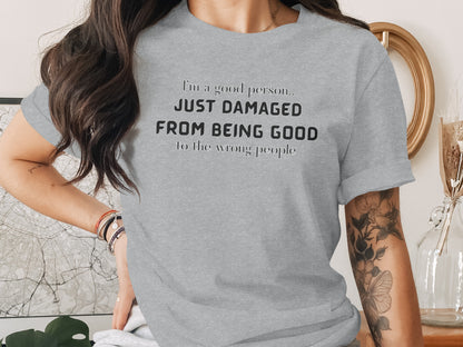 Grey t-shirt with black text reading "I'm a good person.. JUST DAMAGED FROM BEING GOOD to the wrong people".