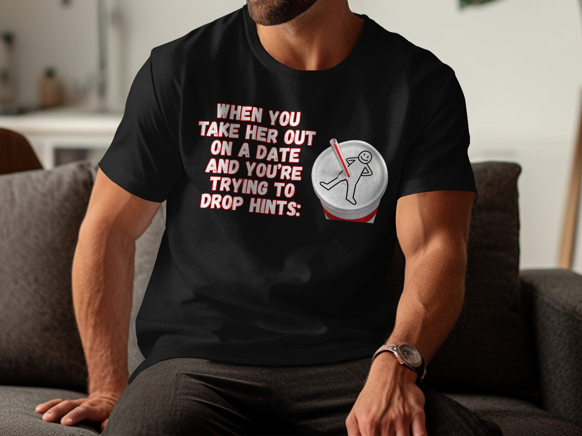 Black t-shirt with "When you take her out on a date and you're trying to drop hints:" and a soda cup with a stick figure.