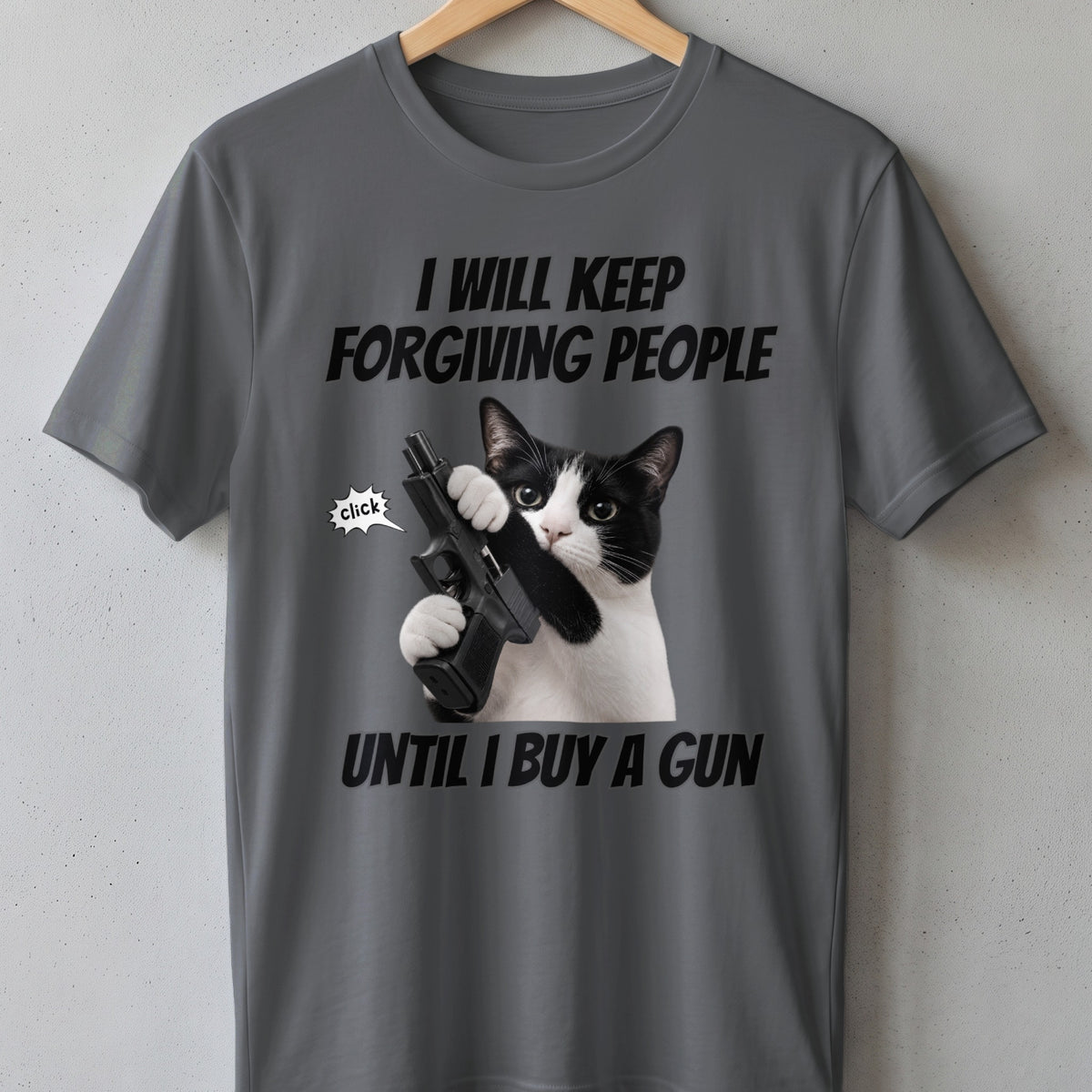 Gray t-shirt with text "I WILL KEEP FORGIVING PEOPLE UNTIL I BUY A GUN" and a cat holding a gun.