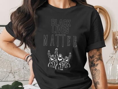 Black Lives Matter text above three gorillas with raised fists on a black t-shirt.