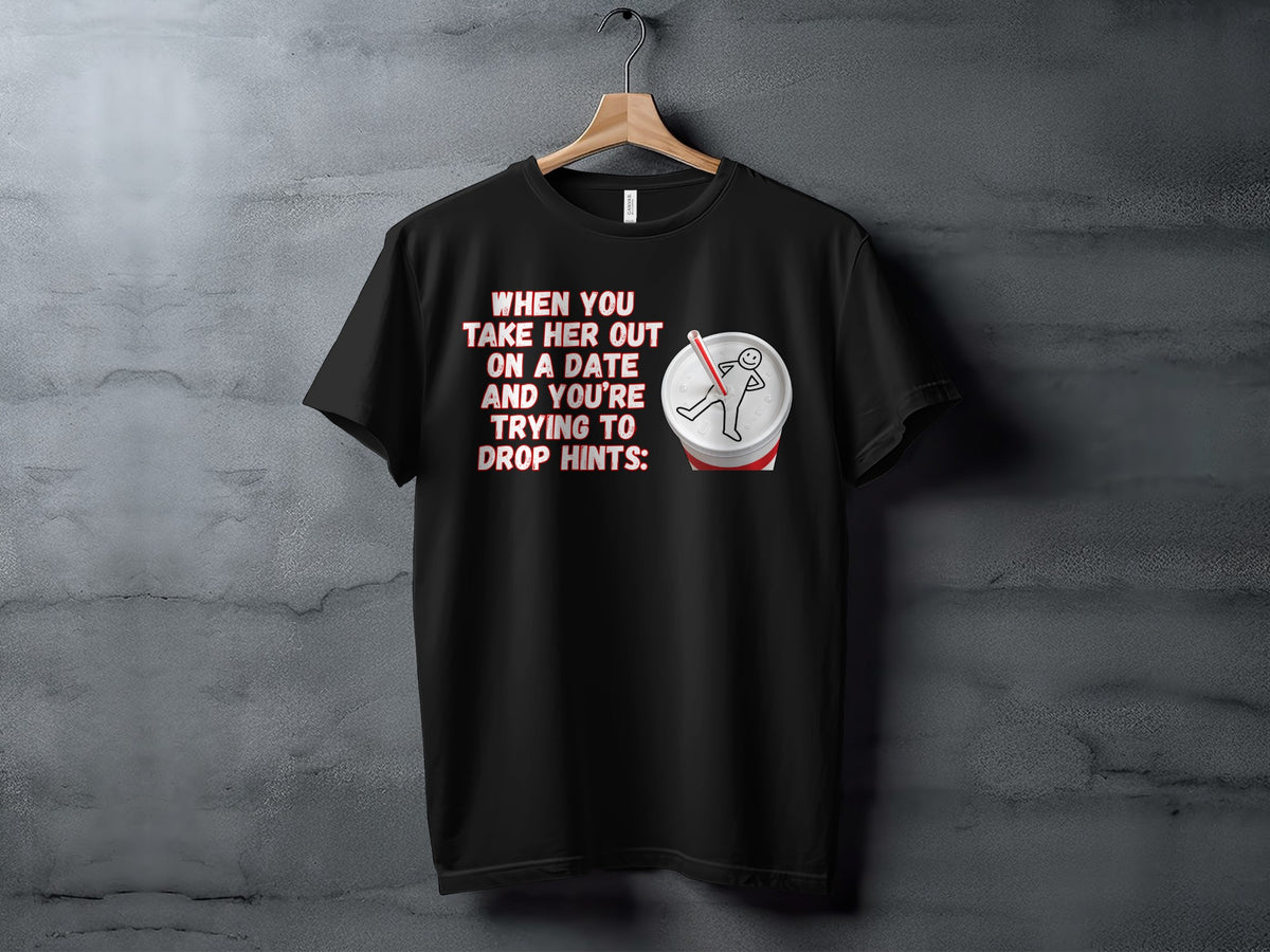 Black t-shirt with text "When you take her out on a date and you're trying to drop hints" and a drawing.