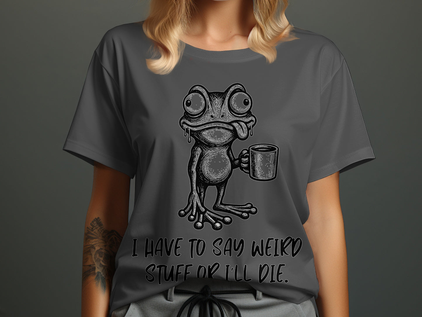 Gray t-shirt with a cartoon frog holding a mug and text reading "I HAVE TO SAY WEIRD STUFF OR I'LL DIE."