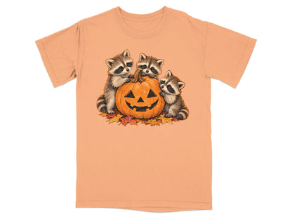 Three raccoons interact with a jack-o'-lantern surrounded by autumn leaves.