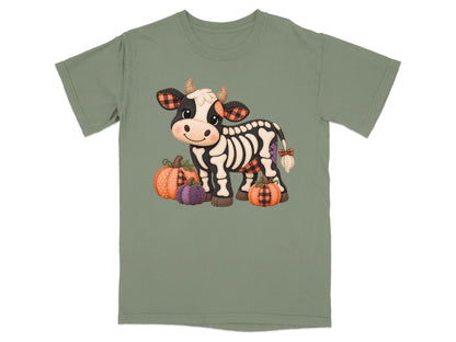 Skeleton cow with plaid accents and pumpkins on a sage green t-shirt.