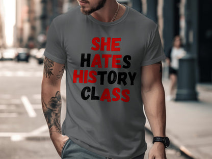 Dark grey t-shirt with red and black text reading "SHE HATES HISTORY CLASS".