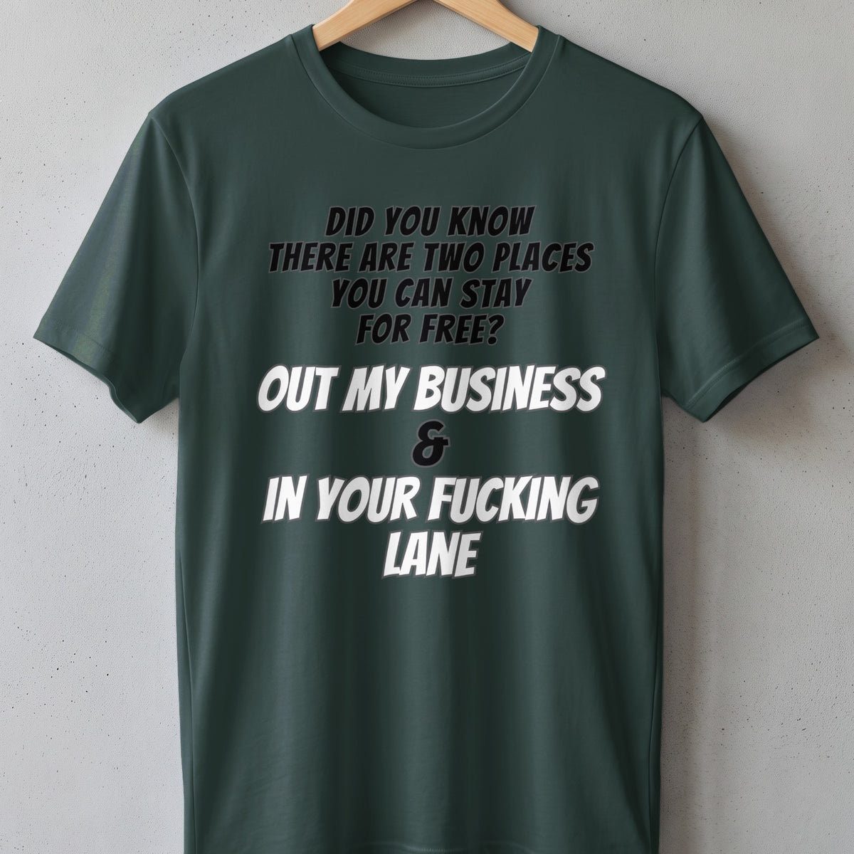 Dark green t-shirt with text "Did you know there are two places you can stay for free? Out my business & In your fucking lane."
